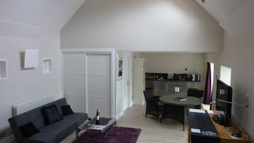 Una sala de estar moderna con sofá, mesa de centro y comedor.