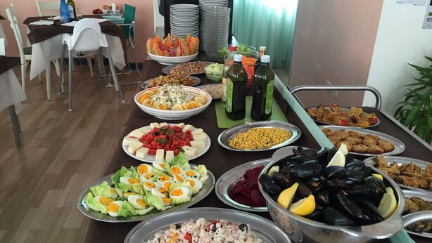 A buffet table with various dishes including salads, seafood, and rice. - Hotel Madrid (Cattolica)