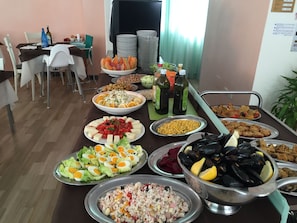 A buffet table with various dishes including salads, seafood, and rice. - Hotel Madrid (Cattolica)
