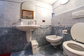 A bathroom with a sink, bidet, toilet, and a mirror. - Dimore Sonore (Gallipoli)