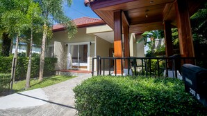 A house with a covered porch, a visible door, and a small garden with a pathway leading to the entrance. - Janthawong Bangtao House (Choeng Thale)