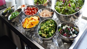 Een buffet met diverse soorten eten, zoals salades, fruit en groenten.