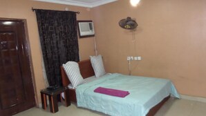 A bedroom with a bed, a desk, and a chair. - B & S Hotel (Lagos)