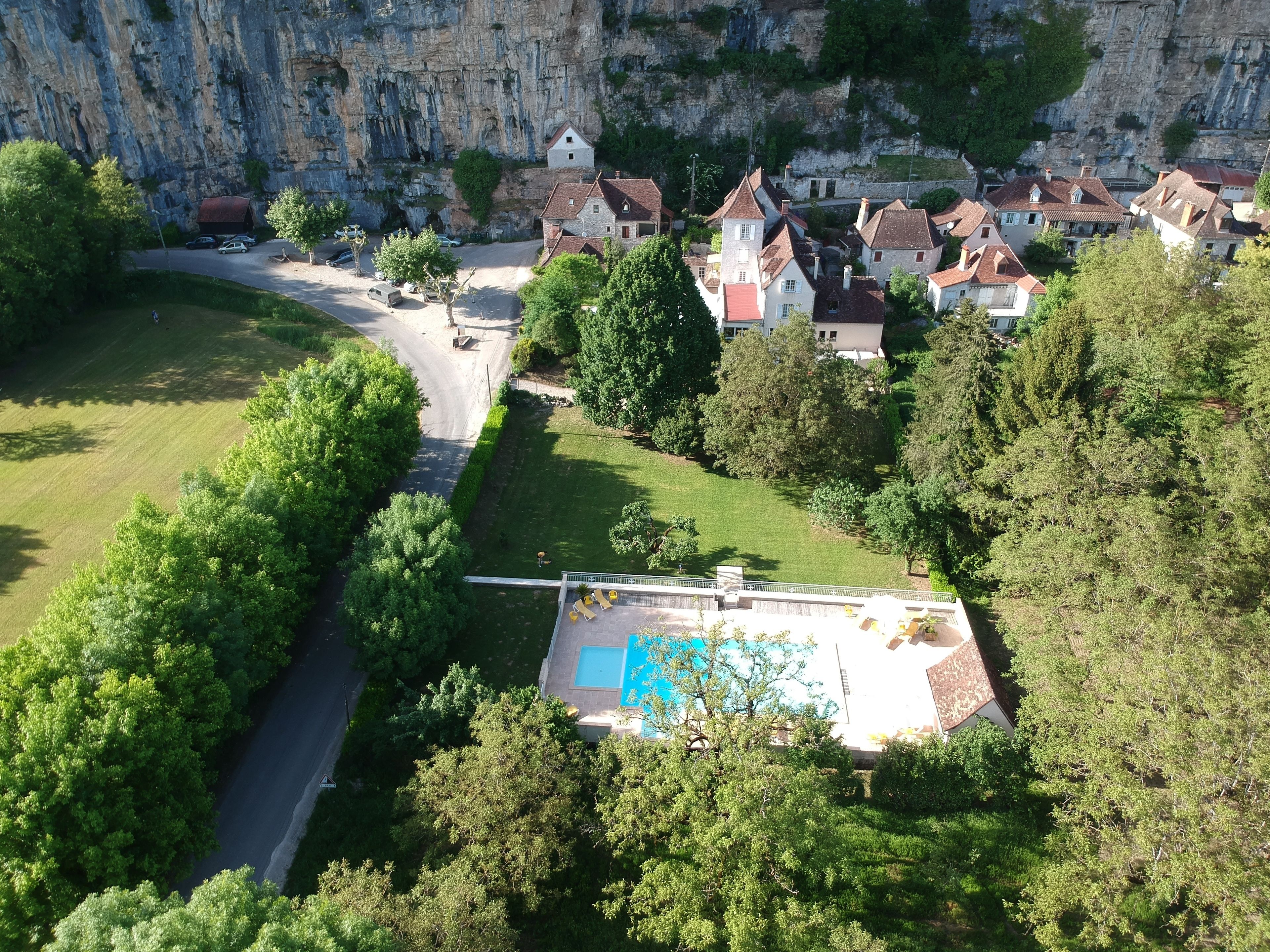 Luchtbeeld van een woongebied met huizen, een weg en een zwembad.