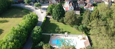 Vista aérea de una zona residencial con casas, una carretera y una piscina.