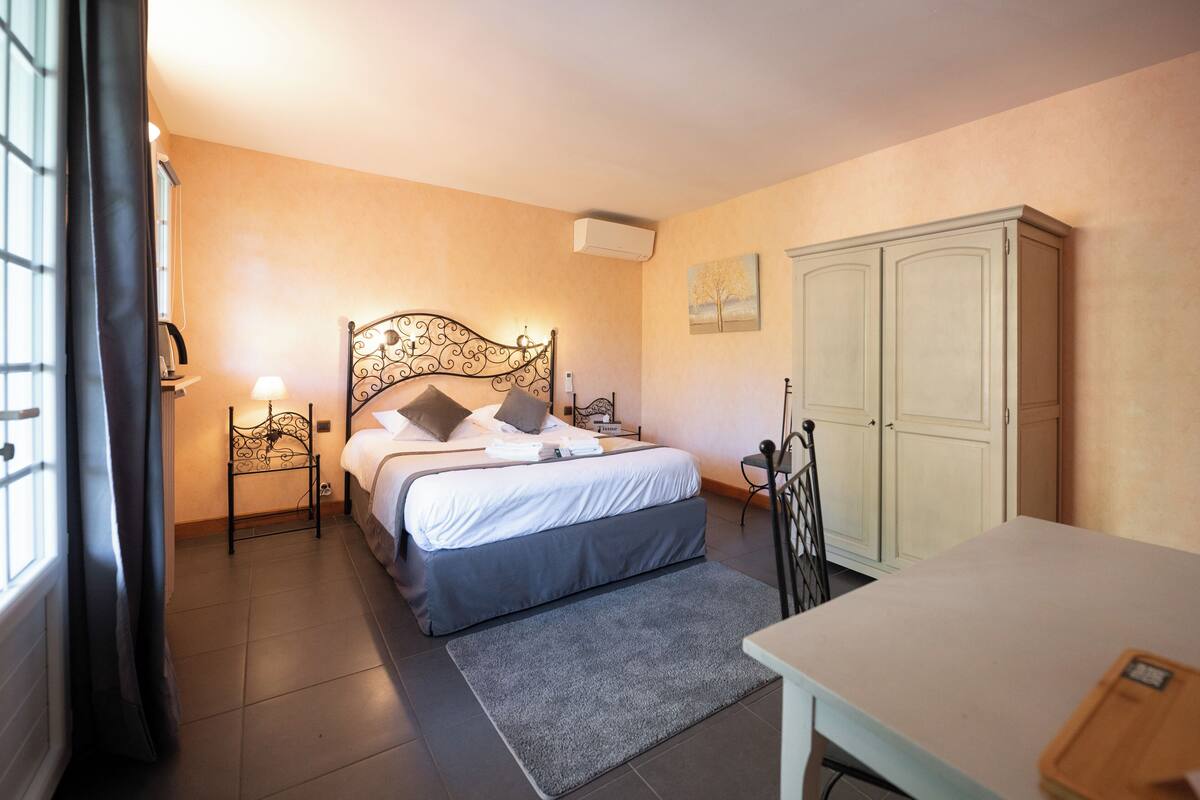 A bedroom with a bed, bedside tables, a wardrobe, and a desk.