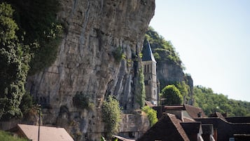 A church built into a cliffside with a steep, rocky facade and a pointed steeple.