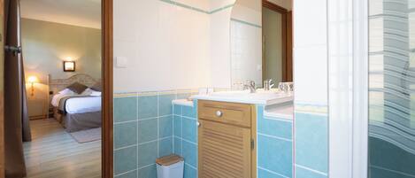 A bathroom with a sink, mirror, and tiled walls.