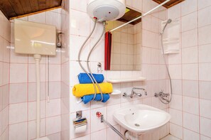 Een badkamer met toilet, wastafel, douche en handdoekrek.
