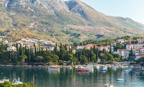Une ville côtière dotée d’un port de plaisance, de maisons aux toits rouges et bordée de montagnes.
