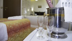 A hotel room with a bed, a minibar, and two glasses on a tray. - Corte Galvana (Cento)