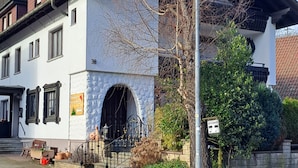 A building with a stone facade, a black metal gate, and a clear sky. - Pension Schlossbergblick (Simonswald)