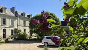 A large, historic building with a driveway and a parked car. - La Pénesais (Beaumont-en-Veron)