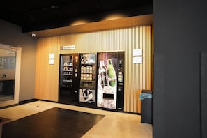 Un quiosco de autoservicio con dispensador de bebidas y punto de alquiler de zapatos.