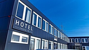 A modern hotel building with a sign indicating a check-in area.