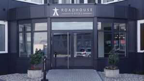 L’extérieur du Roadhouse Hotel présente un design moderne, avec de grandes fenêtres en verre et une entrée imposante.