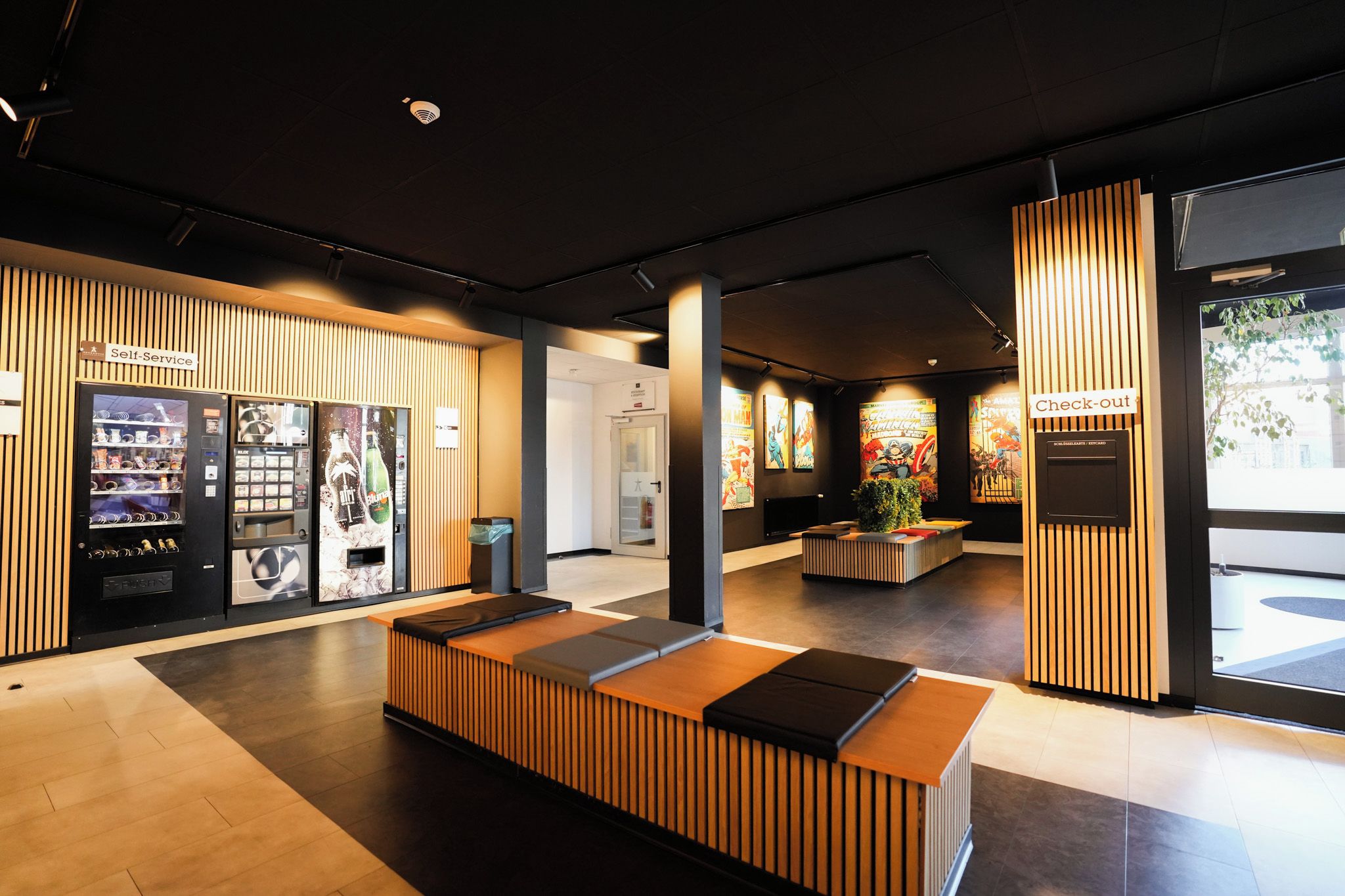 A modern reception area with a self-service kiosk, a check-out counter, and a seating area.
