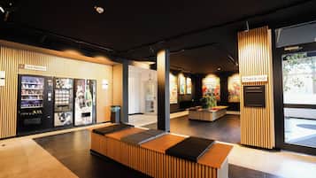 A modern reception area with a self-service kiosk, a check-out counter, and a seating area.