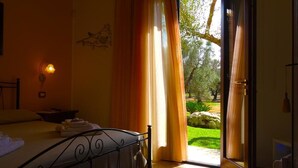 Ein Schlafzimmer mit einem Bett, einem Nachttisch und einem Fenster mit Vorhängen.