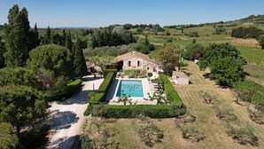 An aerial view of a property with a swimming pool, surrounded by well-maintained gardens and a hilly landscape. - Le Vieux Platane (Cairanne)