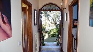 A hallway with a wooden door leading to a garden. - Nature, Relax and Sea view! (Massa Lubrense)