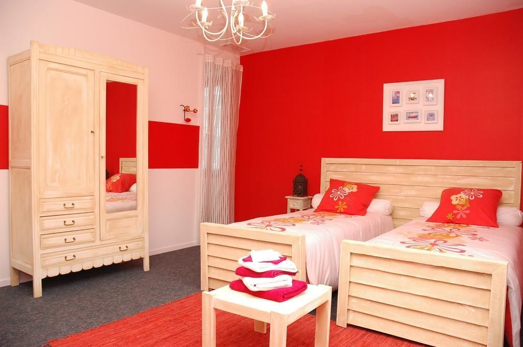 Ein Schlafzimmer mit zwei Betten, einem Kleiderschrank und einer Chandelier.