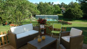 An outdoor patio with wicker furniture, a small table, and a potted plant. - La Palombiere (Lucmau)