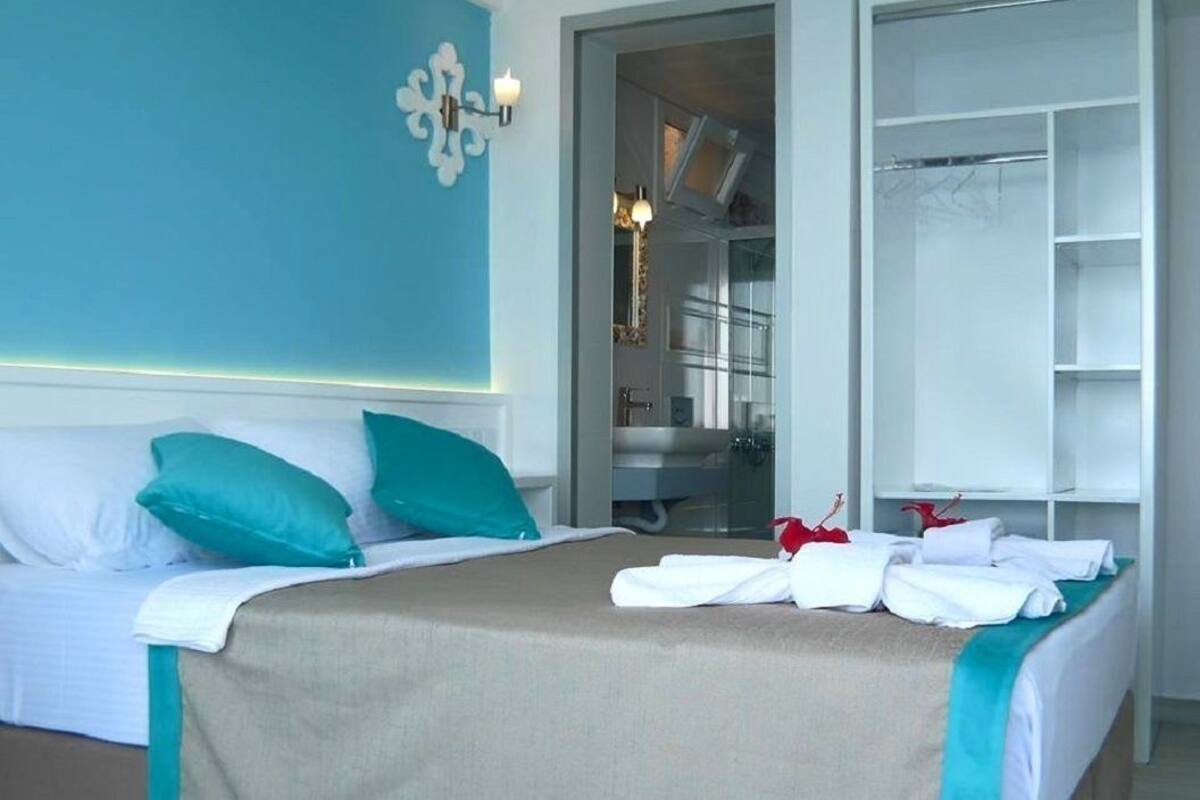 Une chambre d’hôtel comprenant un lit, une salle de bain et un dressing.