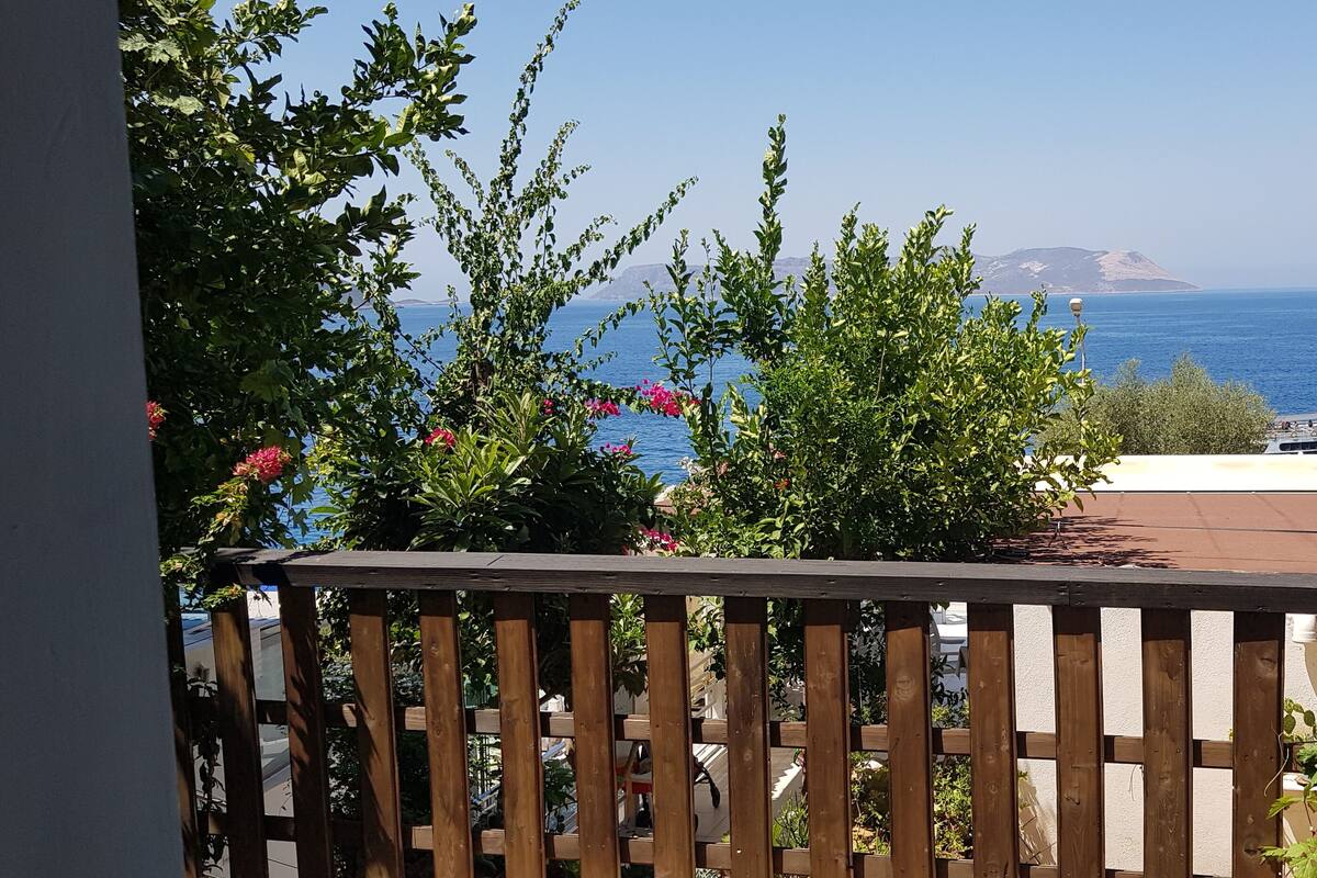 Un balcon avec vue sur la mer et une île au loin.
