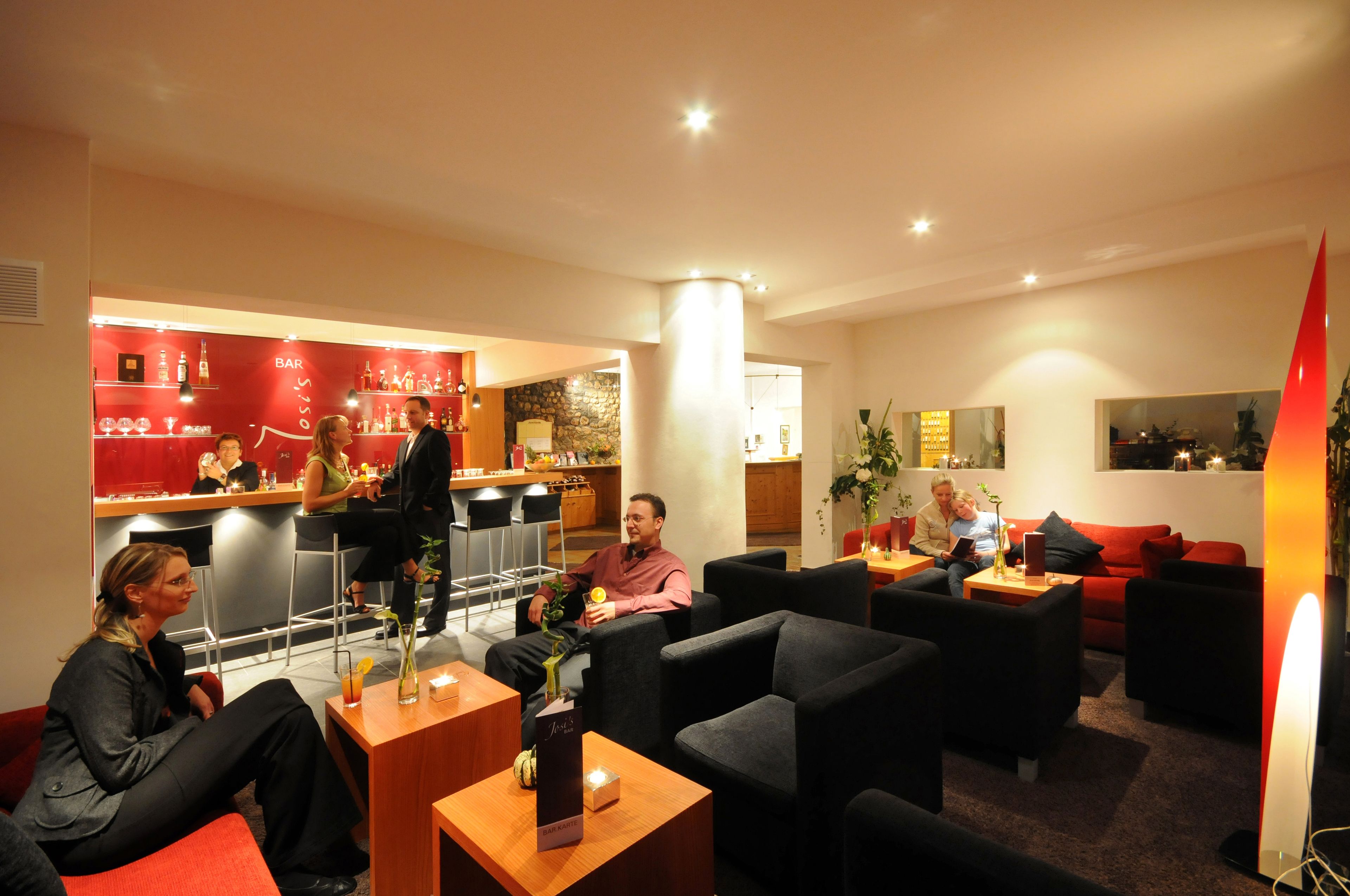 A hotel lobby with a bar area, seating arrangements, and a modern interior design.