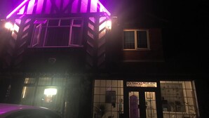 A private hotel with a distinctive triangular roof structure illuminated by purple lights. - The Southwold (Skegness)