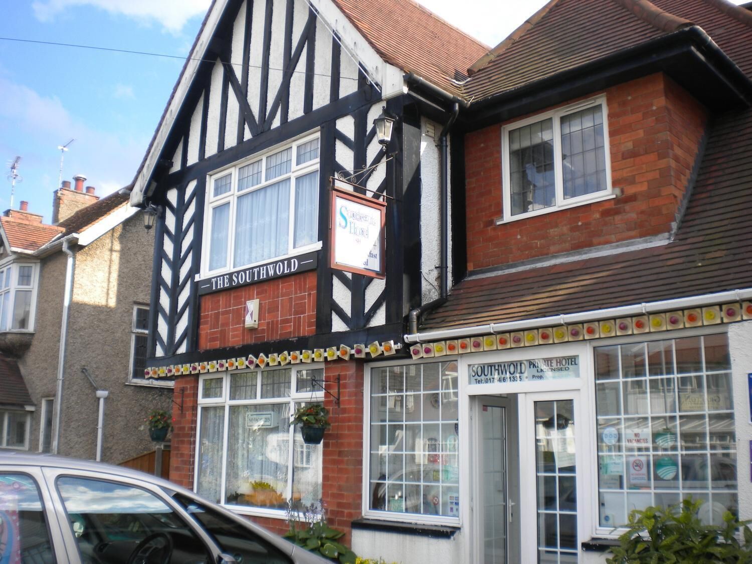 Een traditioneel vakwerkhuis met een bordje voor 'The Southwold Private Hotel'.