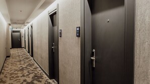 Un pasillo de hotel con varias puertas, algunas de las cuales tienen teclados electrónicos.