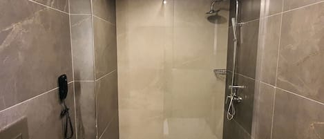 A modern bathroom with a walk-in shower, a toilet, and a bidet.