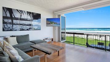 Apartamento família, 3 quartos, vista para a praia, de frente para a praia | Área de estar | TV de tela plana