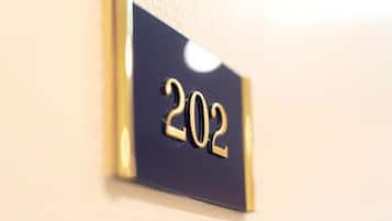 Un gros plan d’une plaque indiquant le numéro de chambre, « 202 », sur un mur.