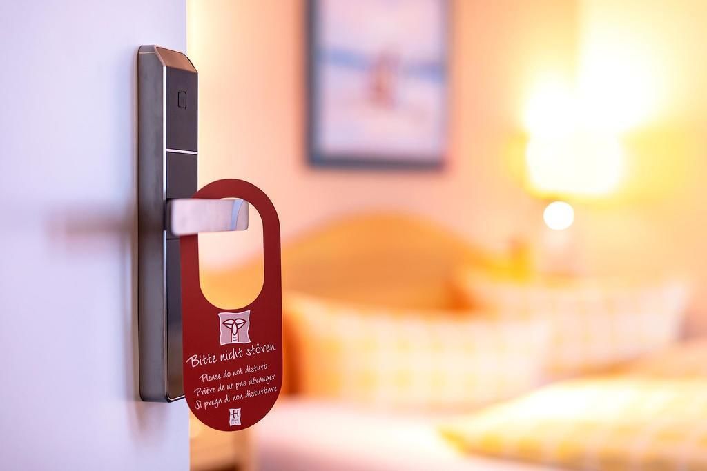 Een hotelkamerdeur met een kaartlezer en een bordje met de tekst ‘niet storen’.