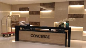 A concierge desk with a sign, a cart, and decorative vases. - Condo Unit With Balcony in Manila (Pasay)