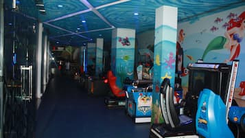 Relax in this ocean-inspired entertainment area, featuring vibrant wave-patterned ceilings and colorful sea creature murals.
