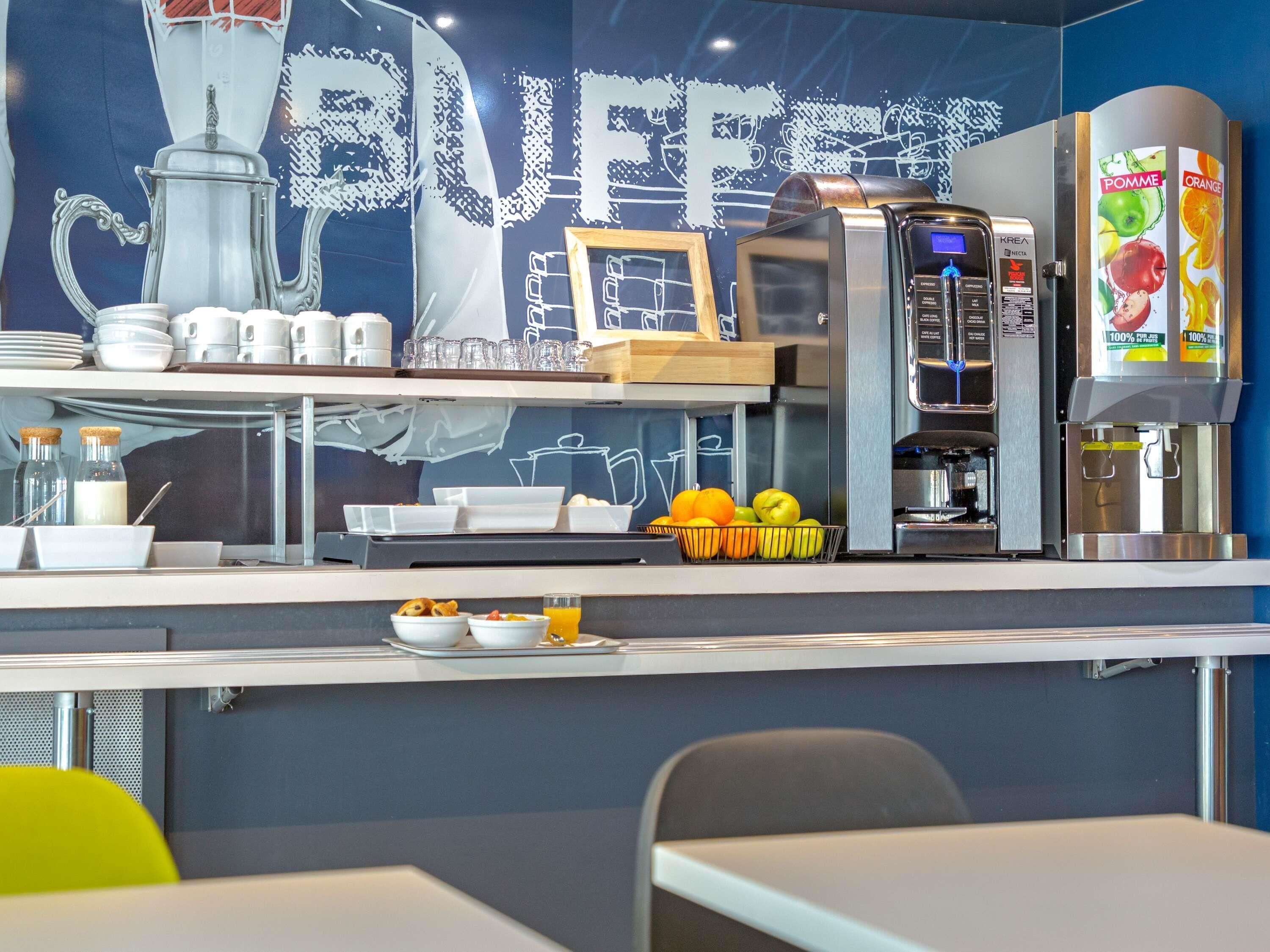 A buffet counter with a coffee machine, a fruit dispenser, and a chalkboard with a 'BUFFET' sign.
