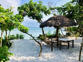 Una playa cerca, arena blanca, sillas reclinables de playa, kayak