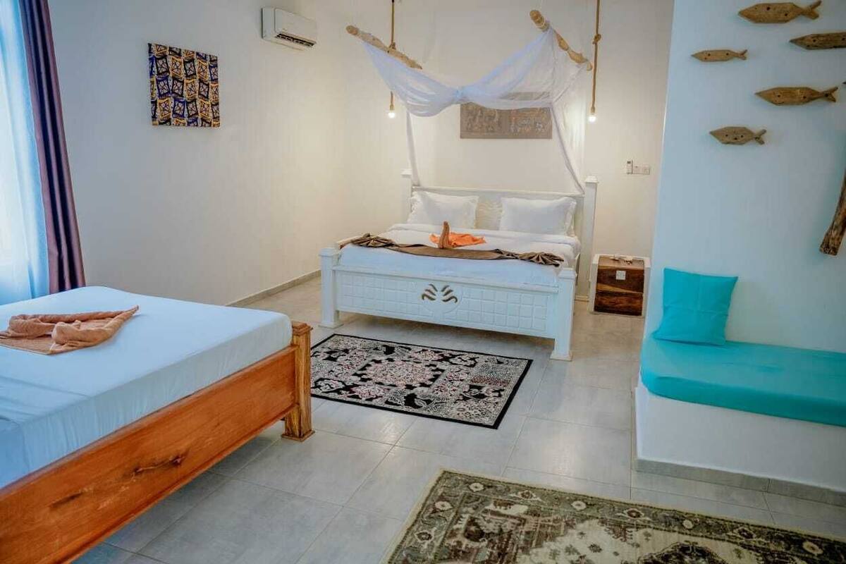 A bedroom with a bed, bedside table, and a sofa.