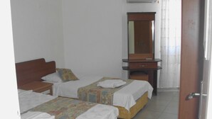 Una habitación de hotel con dos camas, una mesita de noche de madera, un aparador y un espejo.