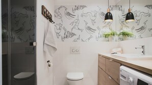 A modern bathroom with a toilet, a washing machine, and a sink. - Apartamenty Gdańsk-Old Town Szafarnia 6a (Gdansk)