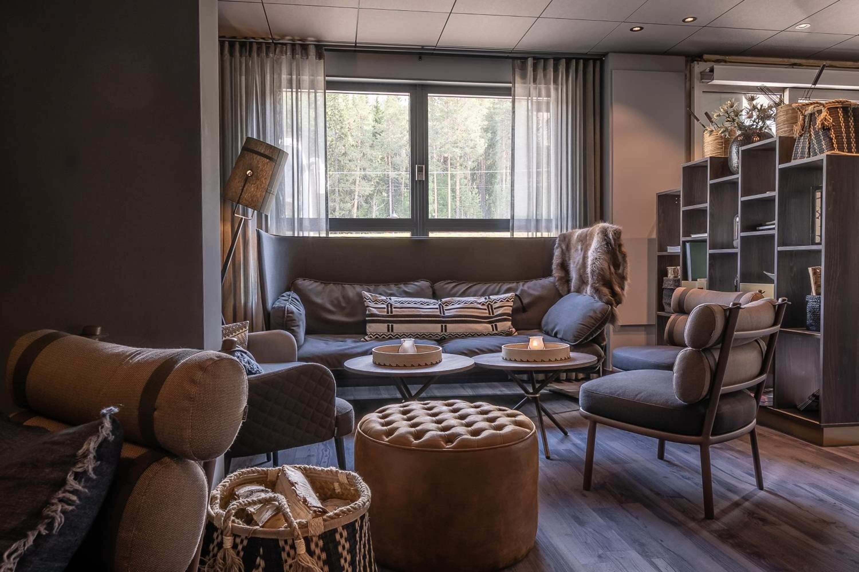 Uma sala de estar moderna com sofá, poltronas, mesa de centro e estante.