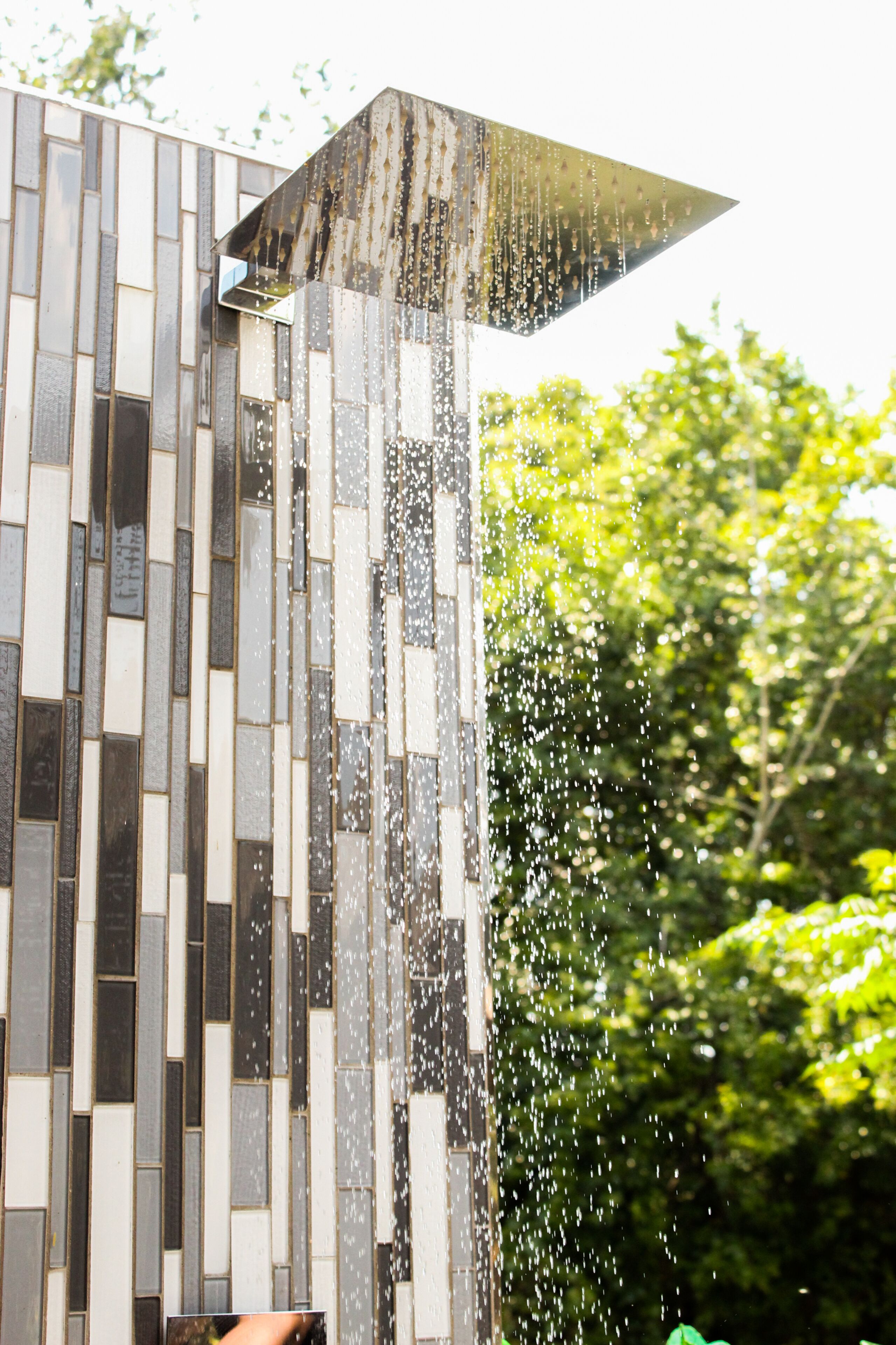 A modern building with a unique geometric facade and a water feature.