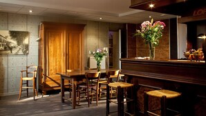 A restaurant with a wooden interior, a bar area, and a dining table with chairs. - Le Jardin de la Reyssouze (Gorrevod)