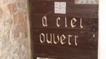 Eine Holztür mit der Aufschrift „à ciel ouvert“ und dekorativen Fliesen.