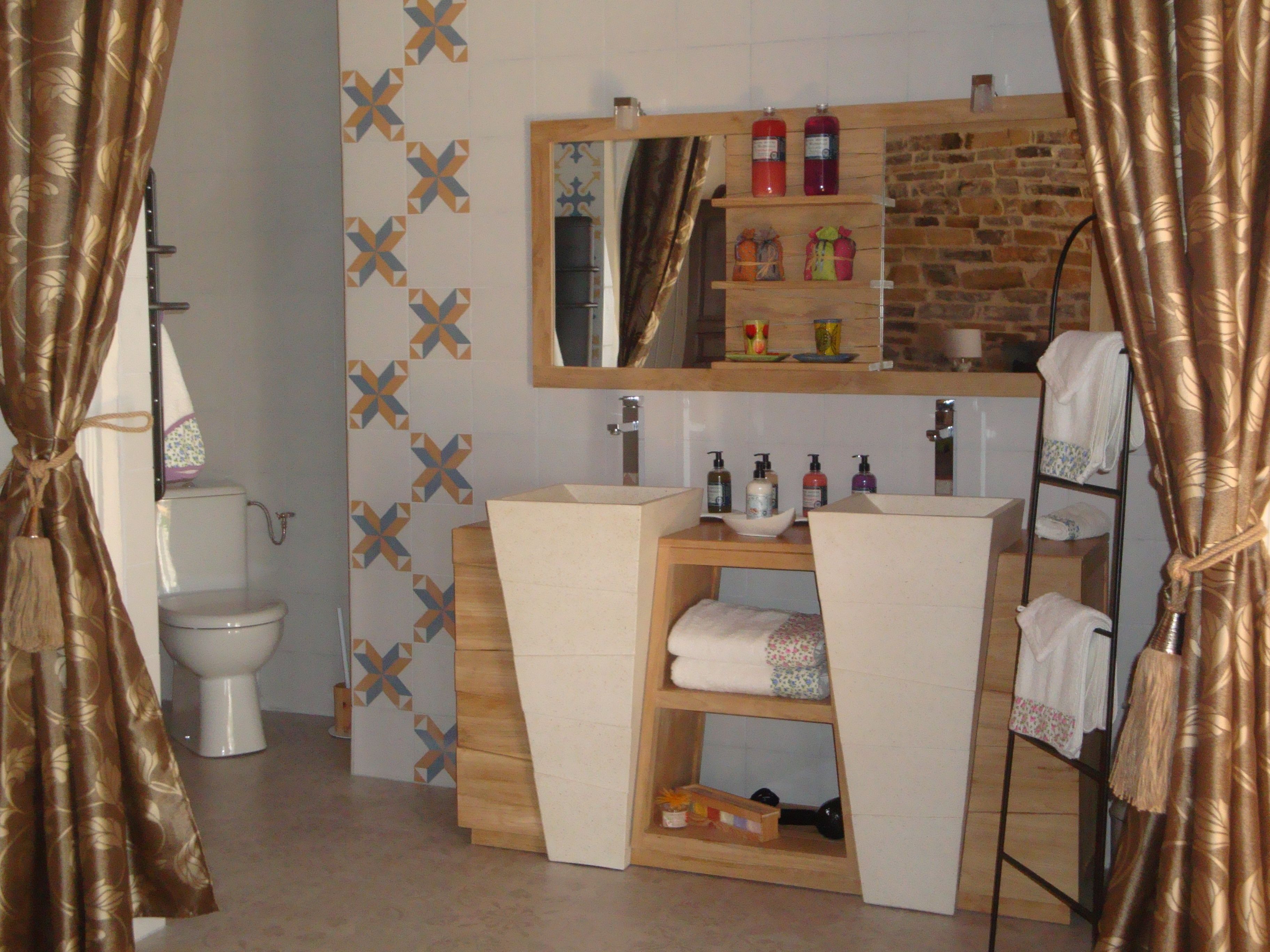 A bathroom with a toilet, sink, mirror, and towel rack.