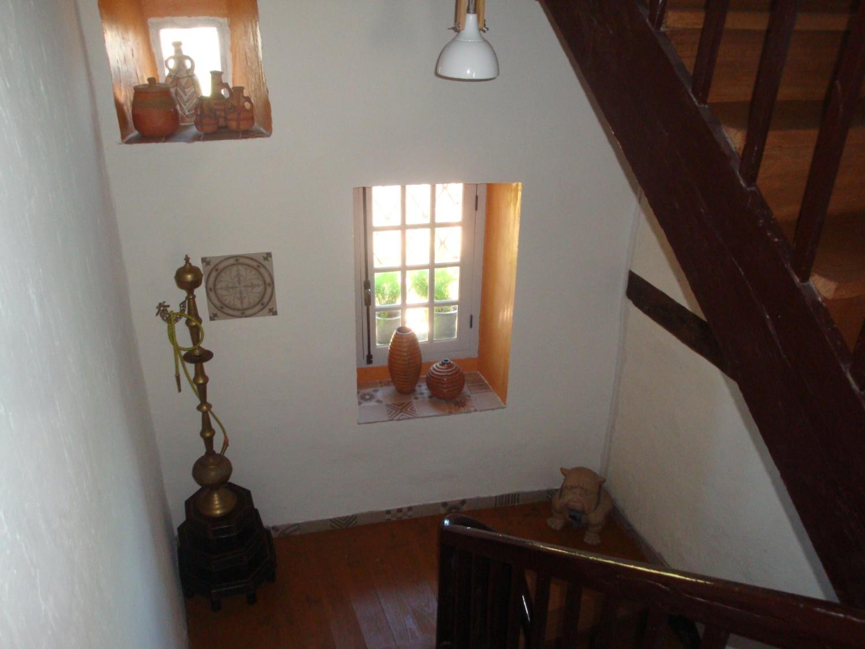 A wooden staircase with a small window and a decorative lamp.